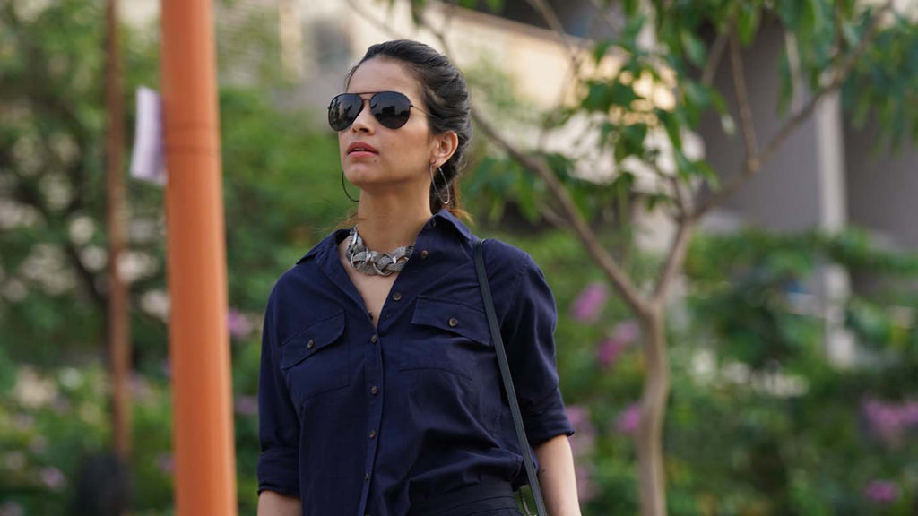 A Woman dresses stylishly in a Navy Utility Pockets Cord Cotton Shirt from Gazillion along with a statement necklace