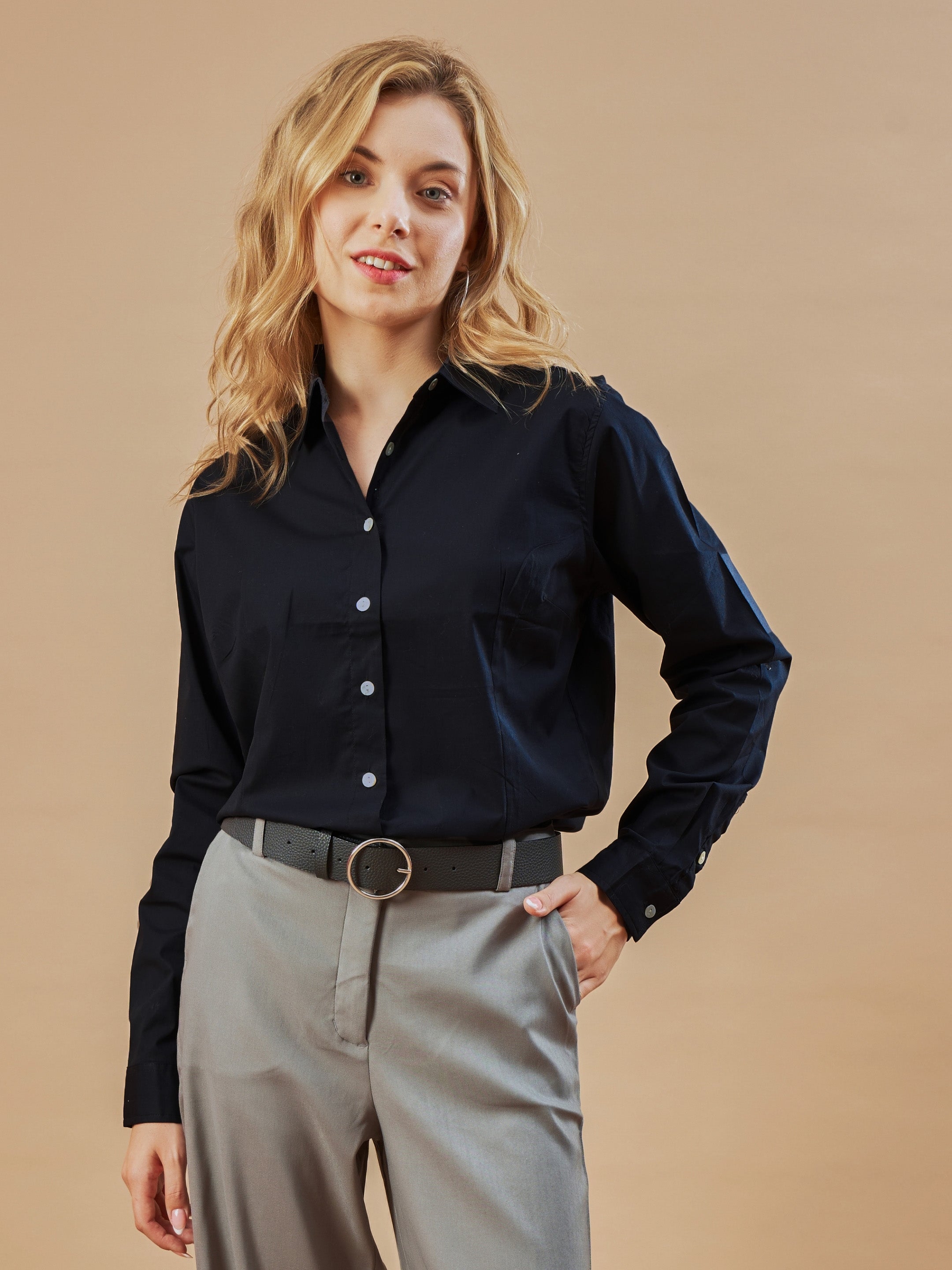 A woman walks in a Formal White Gazillion Shirt tucked into stylish black pants