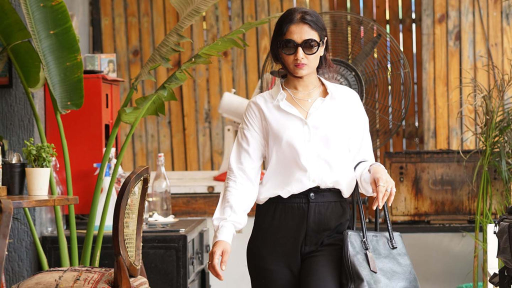 A woman walks in a Formal White Gazillion Shirt tucked into stylish black pants