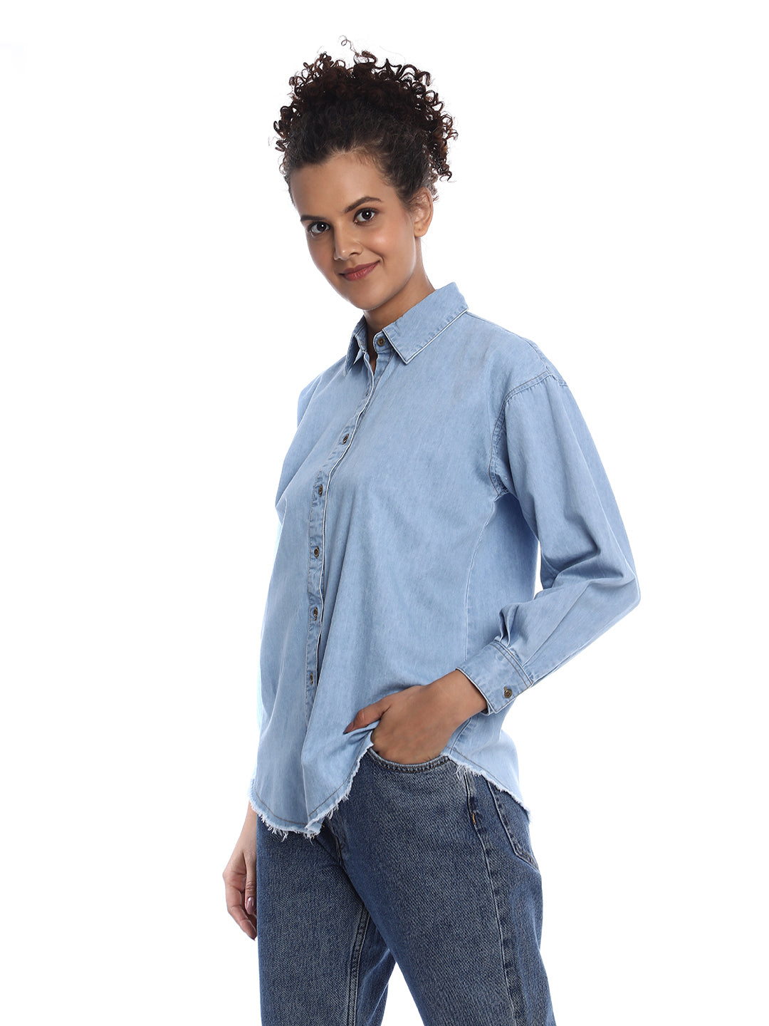 A Woman walking in an Oversized Denim Shirt from Gazillion paired with skinny jeans