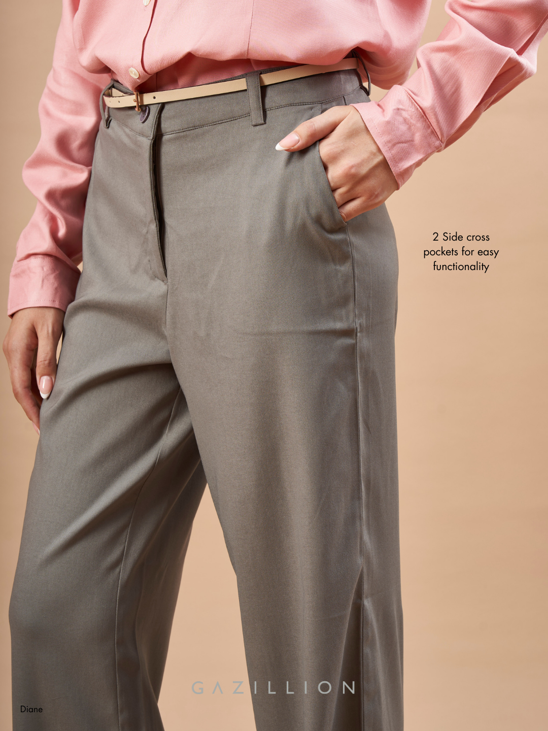 Person wearing gray pants with a pink shirt on a beige background.
