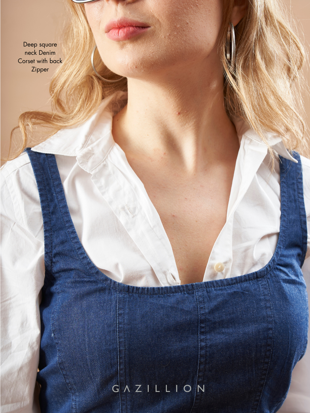 Person wearing a white shirt and blue denim overalls.
